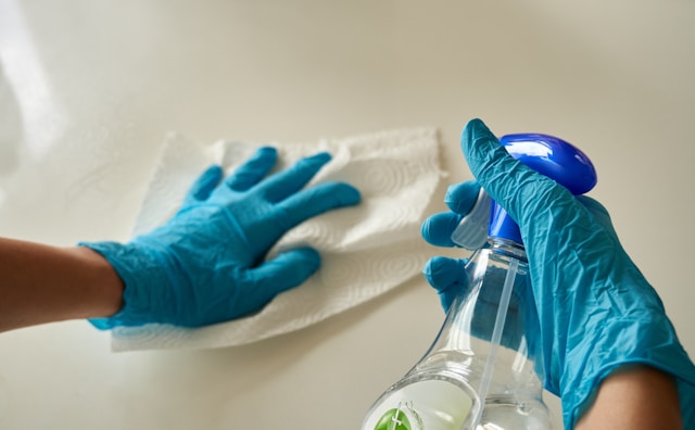someone wearing gloves is assembling a table